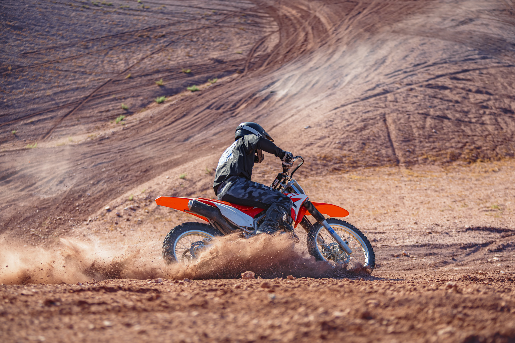 Rider on a dirt bike at Sand Hollow, Utah, kicking up dust on scenic trails near Zion and St. George.