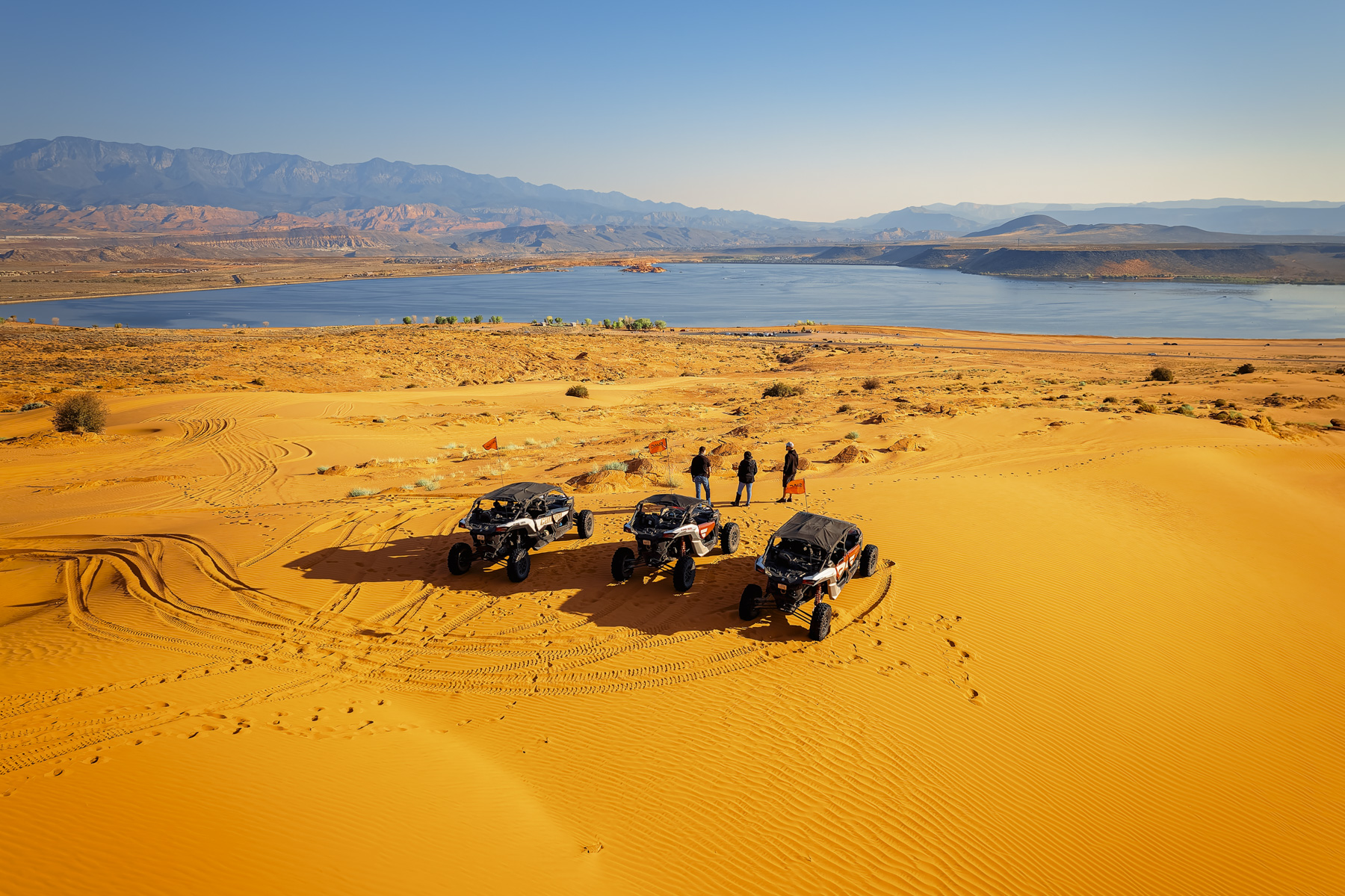UTVs parked on the sand dunes overlooking Sand Hollow Lake in Utah, offering scenic views and off-road adventures near Zion and St. George.