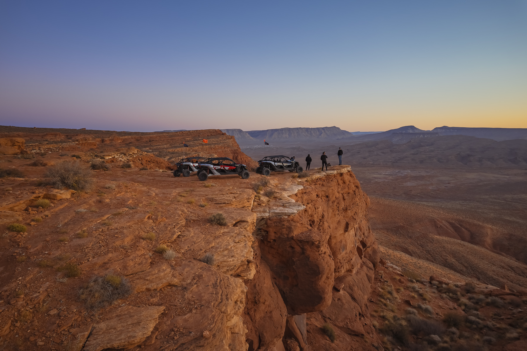 UTVs parked at a dramatic Arizona overlook during the Southern Utah Adventure Center Sunset UTV Tour, offering stunning red rock views and unforgettable Sand Hollow adventures.